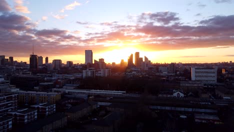 Long-and-slow-drone-shot-city-skyline-silhouetted-at-sunset-in-England