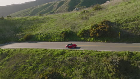 Aerial-drone-shot-flies-over-a-red-Porsche-1993-Carrera-S-in-the-mountains-of-Malibu