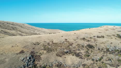 Aerial-reverse-to-reveal-volcanic-peninsula-rocks-as-ocean-disappears-from-view---Banks-Peninsula-South
