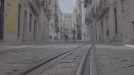 Yellow-tourist-tram-in-the-small-streets-of-Lisboa-Portugal-LOG