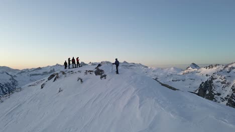 Drohnenaufnahmen-Eines-Mannes,-Der-Mit-Schneeschuhen-über-Einen-Bergrücken-Läuft,-Und-Seiner-Freunde,-Die-Auf-Einem-Schneebedeckten-Gipfel-In-Der-Nähe-Des-Pic-Du-Midi-D&#39;Ossau-Auf-Ihn-Warten