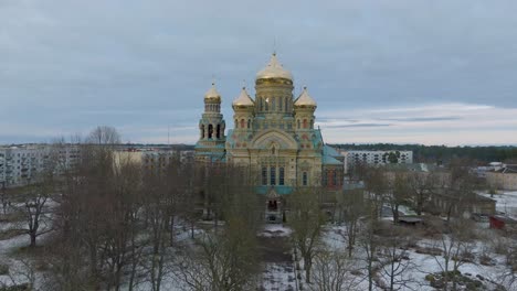 Aerial-establishing-view-of-orthodox-,-wide-drone-shot-moving-forward-over-trees