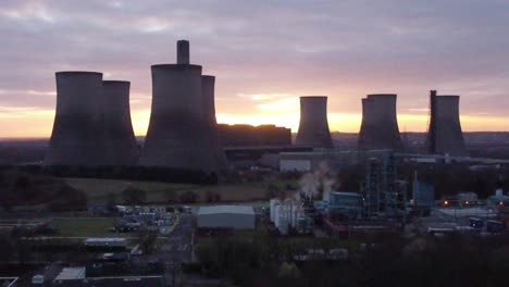 Fiddlers-Ferry-disused-coal-fired-power-station-at-sunrise-behind-landmark,-Aerial-rising-view