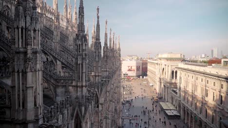 Blick-Vom-Dach-Der-Kathedrale-Duomo-Milano-In-Mailand-Mit-Menschen,-Die-Auf-Einem-Offenen,-Kleinen-Platz-In-Der-Ferne-Spazieren,-Blick-Auf-Die-Innenstadt-Der-Italienischen-Stadt
