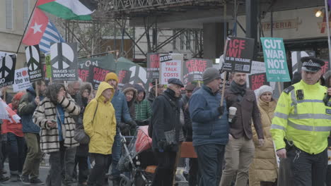 Friedensdemonstranten-Marschieren-Am-25.-Februar-2023-Mit-Transparenten-Und-Fahnen-Durch-Das-Zentrum-Von-London,-Um-Gegen-Den-Krieg-In-Der-Ukraine-Und-Die-Russische-Invasion-Zu-Protestieren