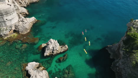 People-kayaking-in-clear-blue-water-in-Dubrovnik,-Croatia