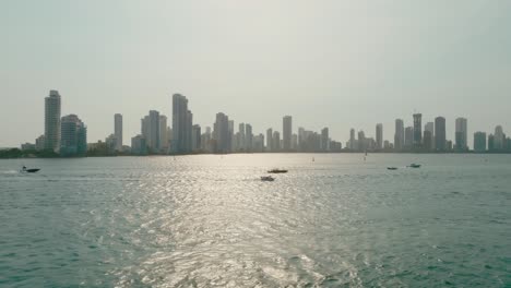 Drohnenschussboote,-Die-Im-Meer-Segeln,-Mit-Der-Stadt-Im-Hintergrund,-Kolumbien,-Cartagena