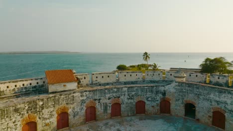 Aerial-drone-shot-of-the-fort-and-Castle-of-San-Luis-de-Bocachica-leaving-to-the-ocean-in-Cartagena,-Colombia