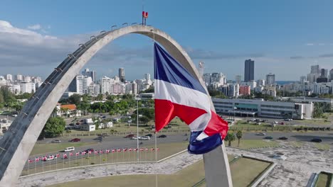 Slow-motion-of-Dominican-Republic-flag-waving-over-triumphal-arch-in-plaza-de-la-Bandera,-Santo-Domingo