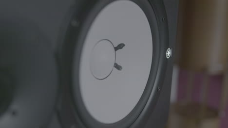 Closeup-of-a-speaker-that's-moving-it's-cone-in-slowmotion-while-playing-music-LOG