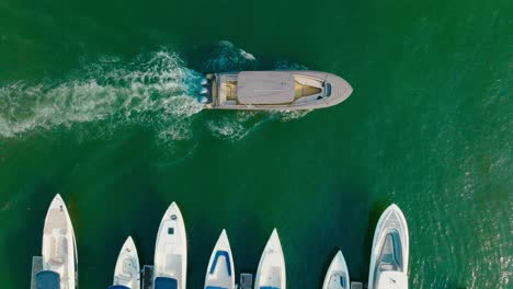 Top-down-Drone-shot-of-a-boat-exit-the-parking,-marina,-Colombia,-Cartagena