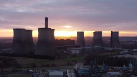 Fiddlers-Ferry-disused-coal-fired-power-station-with-sunrise-behind-landmark,-Aerial-view-orbit-left