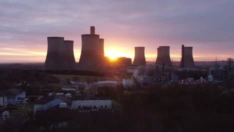 Fiddlers-Ferry-disused-coal-fired-power-station-as-sunrise-hides-behind-landmark,-Aerial-view-descending-shot