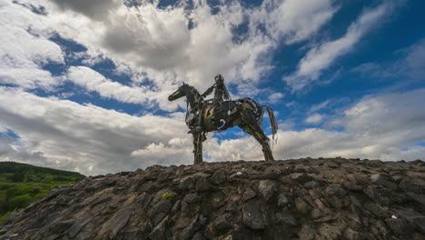 Time-lapse-of-the-Gaelic-Chieftain-modern-art-metal-statue-on-sunny-day-with-moving-clouds-in-the-sky-in-county-Roscommon,-Ireland
