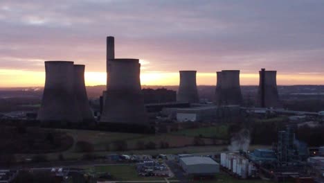 Fiddlers-Ferry-disused-coal-fired-power-station-with-sunrise-across-landmark,-Aerial-descending-view