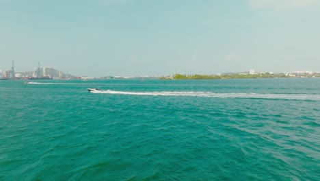 Luftdrohnenaufnahme-Eines-Bootes-Im-Meer,-Das-In-Kolumbien,-Cartagena,-Von-Rechts-Nach-Links-Fährt