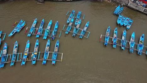 Aerial-top-down-shot-traditional-blue-colored-fisherman-parking-at-harbor-of-BARON-BEACH,-YOGYAKARTA,-INDONESIA
