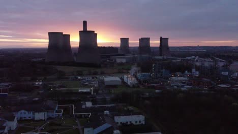 Fiddlers-Ferry-disused-coal-fired-power-station-at-sunrise-golden-hour-behind-Warrington-landmark,-Aerial-view-orbit-right