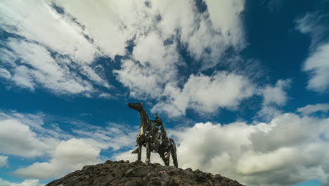 Time-lapse-of-the-Gaelic-Chieftain-modern-art-metal-statue-on-sunny-day-with-moving-clouds-in-the-sky-in-county-Roscommon,-Ireland