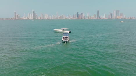Aerial-Drone-shot-of-a-boat-going-to-help-a-stranded-boat-in-the-ocean,-Colombia,-Cartagena