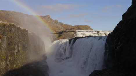 Aerial-shot-from-the-canyon-at-Gullfoss,-Iceland,-with-a-rainbow-in-the-waterfall