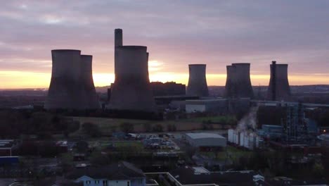 Fiddlers-Ferry-disused-coal-fired-power-station-with-sunrise-skyline,-Aerial-view-descending-to-power-plant