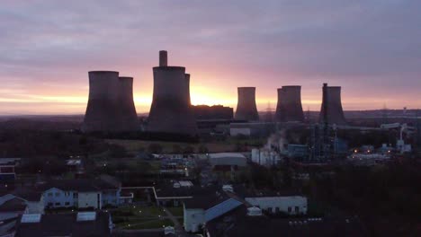 Fiddlers-Ferry-disused-coal-fired-power-station-with-sunrise-horizon-behind-landmark,-Aerial-view-orbit-right