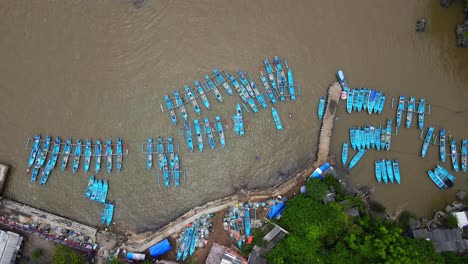 Aerial-top-down-shot-of-several-blue-fisherman-boats-anchored-at-harbor-of-YOGYAKARTA,-INDONESIA