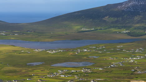 Zeitraffer-Eines-Küstendorfes-Und-Einer-Seehanglandschaft-Mit-Wolken,-Die-Bei-Tageslicht-Schatten-Werfen,-Aus-Minaugn-Höhen-Auf-Achill-Island-In-Der-Grafschaft-Mayo-In-Irland