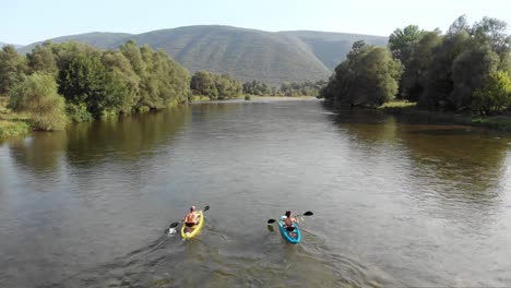 Drone-video-flying-upwards-following-two-people-kayak-Nestos-river-Greece-summer
