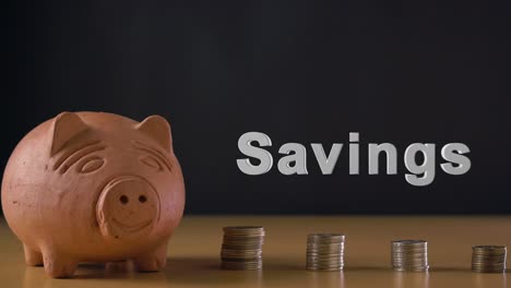 Savings-text-and-hand-of-a-white-man-putting-a-coin-in-a-clay-piggy-bank