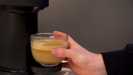 Male-hand-picking-up-a-white-coffee-from-an-espresso-machine