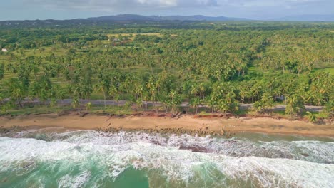 Drone-shot-of-beautiful-exotic-landscape-with-sandy-beach-and-ocean-waves-during-cloudy-day---Mountains-range-in-background---trucking-shot