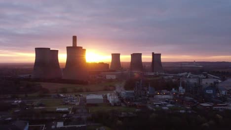 Fiddlers-Ferry-disused-coal-fired-power-station-as-sunrise-emerges-from-behind-landmark,-Aerial-view-orbit-right