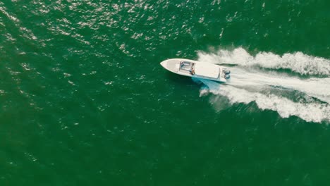 Aerial-top-down-Drone-shot-of-boat-sailing-the-ocean-fast,-Colombia-Cartagena