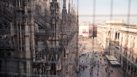 View-from-roof-of-cathedral-Duomo-Milano-in-Milan-with-people-walking-on-open-square-small-in-distance,-downtown-view-Italian-city