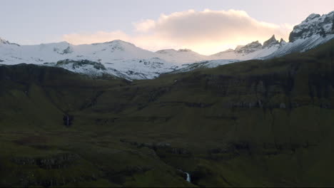 Mountain-landscape-in-Iceland-with-snowcapped-mountains,-waterfalls-and-beautiful-evening-sun