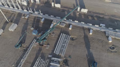 Drone-shot-of-crane-with-material-on-construction-site