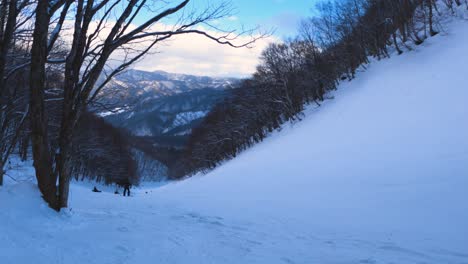 Snowboarding-going-down-hill-through-the-mountains-of-Hida,-Gifu-Japan
