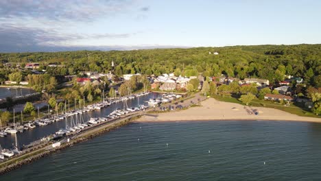 Iconic-American-township-with-pier-and-sail-boats-on-sunny-day,-aerial-view