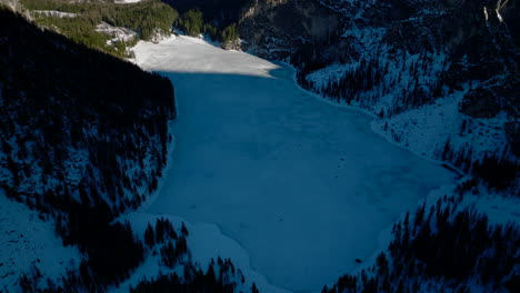 Cinematic-Aerial-View-Of-Shadowed-Frozen-Lake-Lago-di-Braies