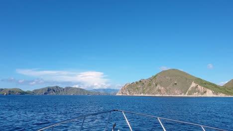 Overlooking-the-bow-front-of-tour-boat-moving-fast-over-ocean-with-view-of-tropical-islands-in-Komodo-National-Reserve-in-Indonesia