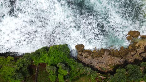 Luftaufnahme-Von-Oben-Nach-Unten-Von-Gigantischen-Wellen,-Die-Gegen-Die-Felsige-Klippenküste-In-Indonesien-Krachen