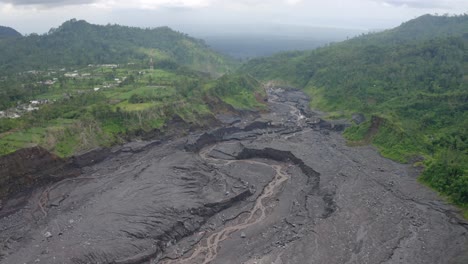 Aerial-view-of-the-volcanic-destruction-left-in-the-middle-of-a-tropical-rainforest,-East-Java-Indonesia