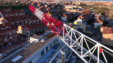 Aerial-overhead-view-of-a-crane-over-a-city,-drone-shot
