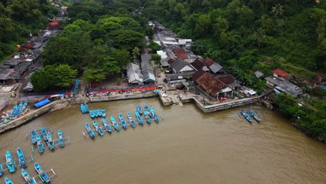 Aerial-footage-of-fishing-port-with-many-boat-anchored-on-it-with-fish-auction---Baron-Beach,-Indonesia