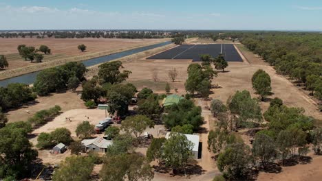 Luftaufnahme-Eines-Bauernhofs-Mit-Einer-Koppel-Aus-Solarenergie-Solarpaneelen,-Die-Grüne-Energie-In-Australien-Zeigen