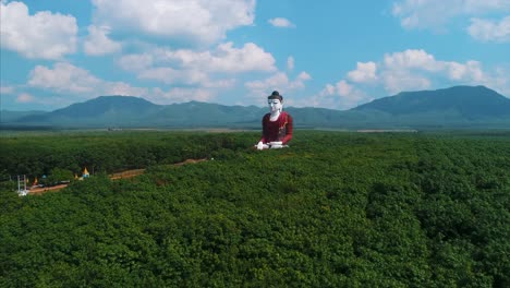 Unglaubliche-Riesige-Buddha-Luftstatue-Asiens-Landschaft-Gummibäume-Umkreisen-Drohne