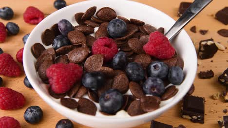 Putting-raspberries-into-a-full-bowl-of-breakfast-cereal