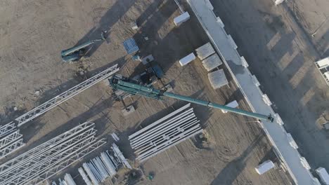 Drone-shot-from-above-a-construction-site-closing-up-on-a-crane
